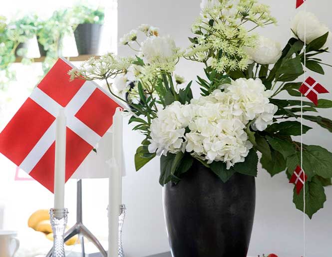 Studenterfest med danske flag og hvide hortensia i vase
