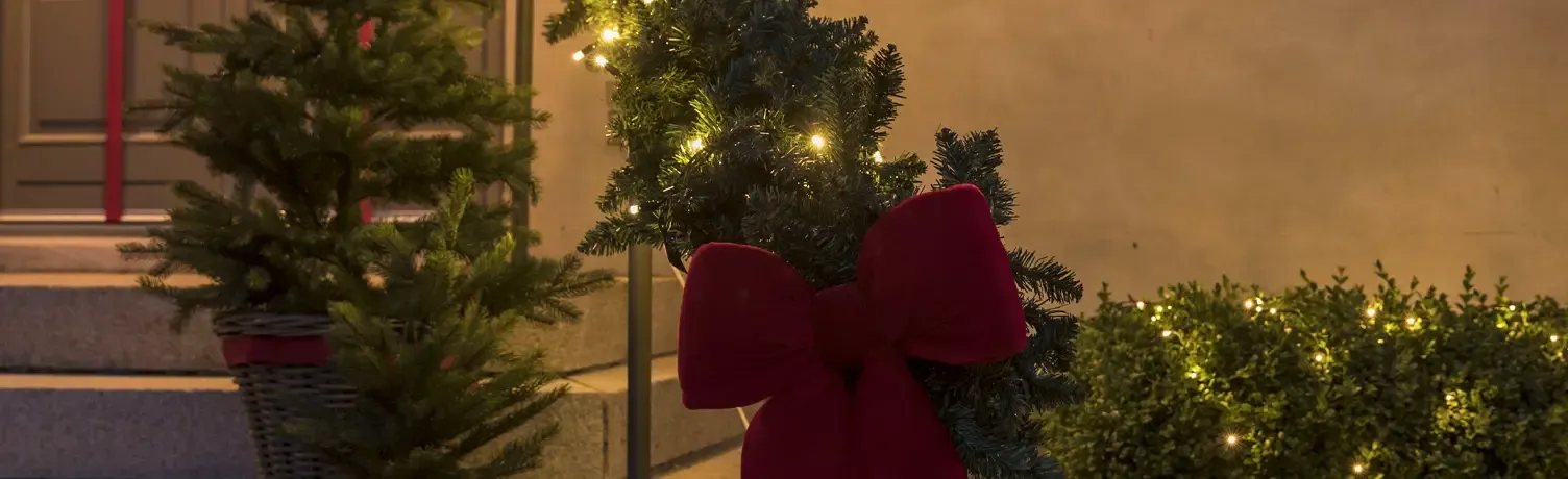hyggelig julebelysning med kunstig gran og lyskæder på indgang til hus