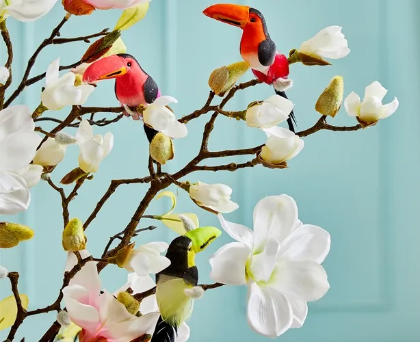 Kunstige tukan fugle på klips sat på kunstige magnoliagrene